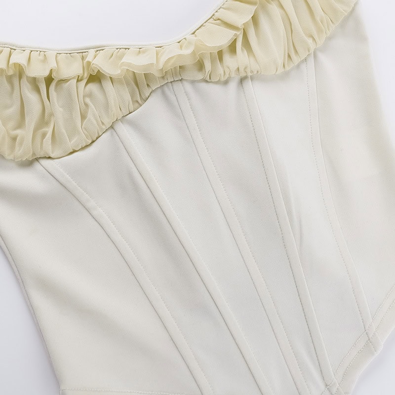 Corset top with beige ruffled neckline and structured white design, perfect for fashion-forward look and waist shaping. Ideal for stylish outfits and enhancing silhouette.