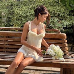 Bright, descriptive image of a woman on a wooden bench holding a bouquet of white flowers, promoting skincare, beauty, and wellness products at Monalisa Store.