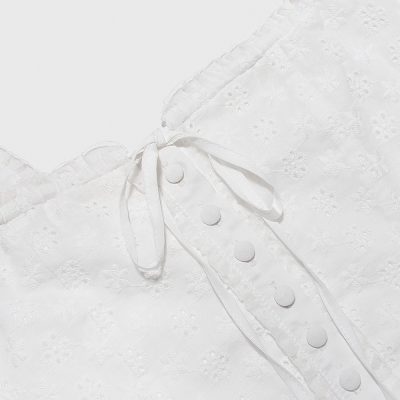 Soft, detailed close-up of white lace fabric featuring buttons and floral embroidery, ideal for wedding dresses or elegant fashion accessories. from Monalisa Store, specializing in premium bridal and evening wear with intricate lace designs.