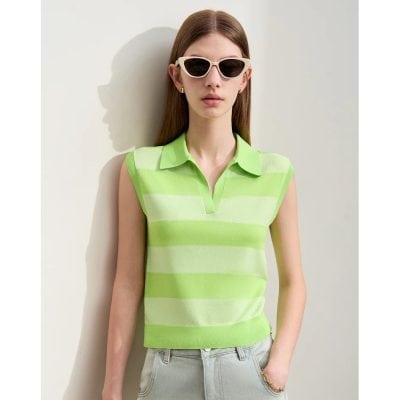 Elegant woman wearing a bright green and white striped sleeveless polo shirt with a collar, paired with sunglasses, showcasing fashionable eyewear at Monalisa Store.