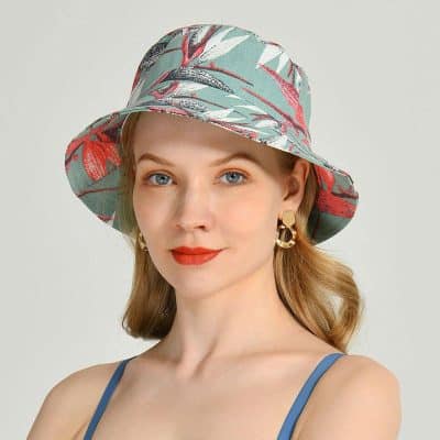 A stylish woman wearing a floral patterned sun hat perfect for summer outings, offering sun protection and fashion appeal, available at Monalisa Medical.