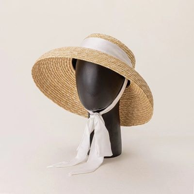 Elegant wide-brim straw sunhat with white ribbon, perfect for sun protection and fashion. Ideal accessory for summer outings, beach days, and outdoor events.