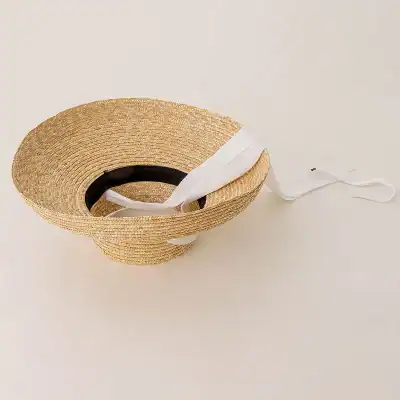 Wide-brim straw sun hat with white ribbon for sun protection and stylish summer eyewear fitting. Perfect for beach, outdoor activities, and fashion accessories.