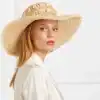 Elegant straw hat with seashell embellishments, perfect for summer or outdoor events. Stylish sun protection accessory for women.