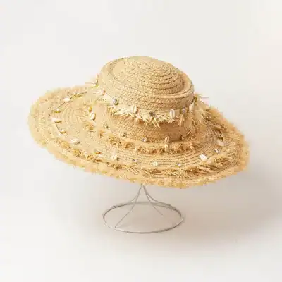 Stylish wide-brim straw hat decorated with shells and beads, ideal for beach outings and summer fashion. Lightweight and breathable for sun protection.