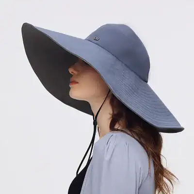 Elegant large sun hat with wide brim, UV protection, and adjustable chin strap for women, perfect for outdoor activities and beach outings.