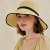Women's fashionable straw sun hat with wide brim and black ribbon.