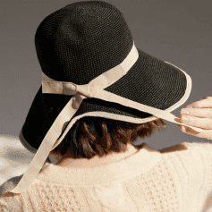 Elegant black sun hat with wide brim and beige ribbon, perfect for sun protection and fashion, ideal for outdoor activities and beach days.