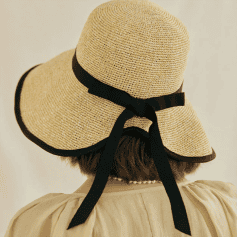 Stylish wide-brim straw hat with black ribbon for sun protection and fashion.