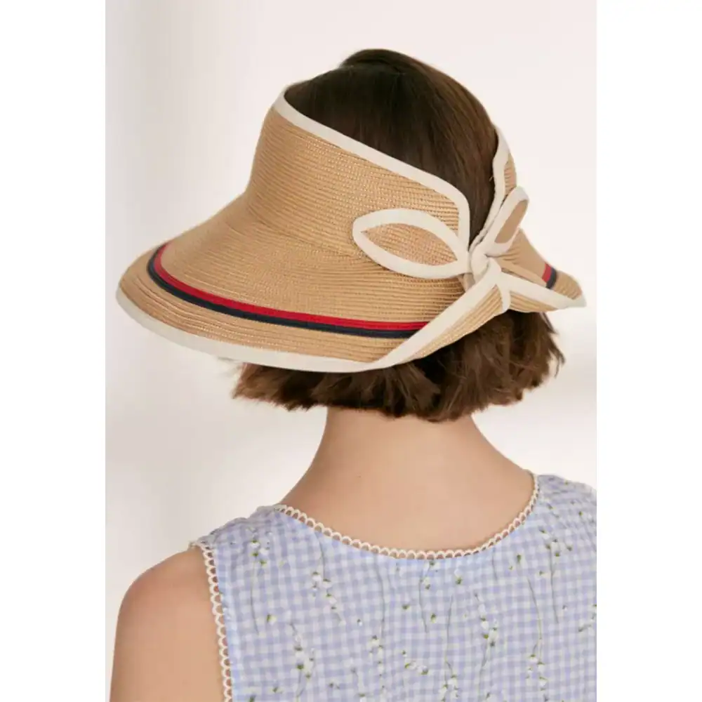 Chic beige sun hat with wide brim and decorative ribbon bow, perfect for summer fashion and outdoor protection. Ideal for women seeking stylish sun protection accessories.