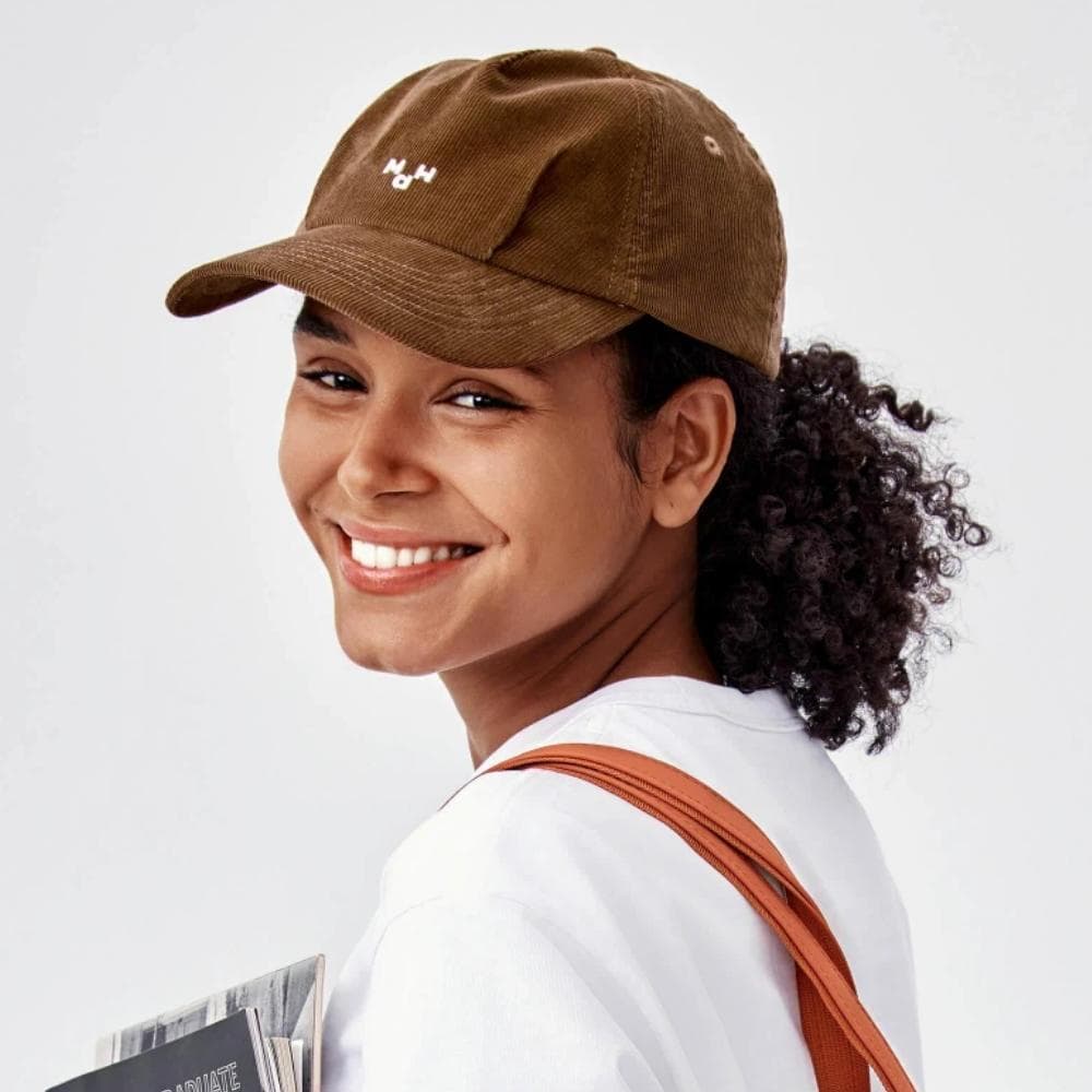 Close-up of a smiling woman wearing a trendy brown cap, ideal for both men and women. Perfect for outdoor, casual, and fashion-forward looks, available at Monalisa Store.