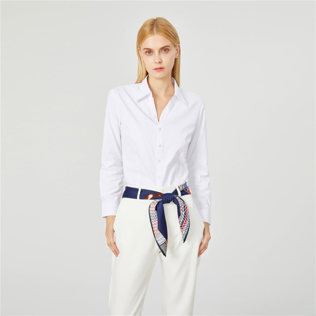 Elegant white button-down blouse styled with a designer scarf belt around the waist, perfect for professional or casual fashion statements.