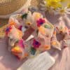 Embroidered fabric scrunchie with vibrant floral pattern, perfect for hair styling and accessories. Made from soft, lightweight material ideal for everyday wear or special occasions.