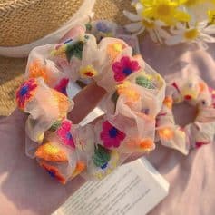 Embroidered fabric scrunchie with vibrant floral pattern, perfect for hair styling and accessories. Made from soft, lightweight material ideal for everyday wear or special occasions.