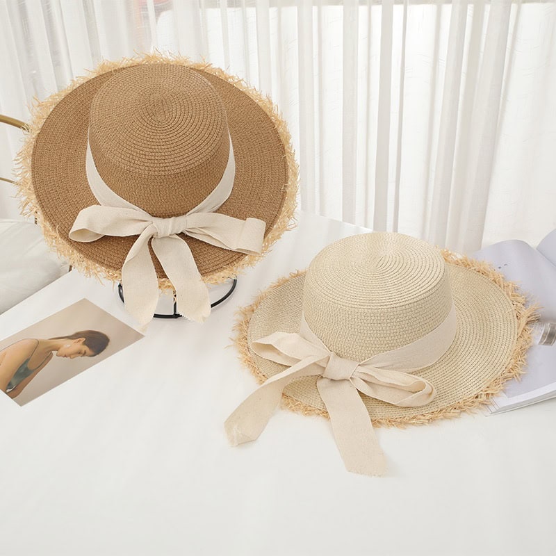 Stylish straw sun hat with a wide brim and elegant bow, perfect for summer outdoor activities and sun protection. Lightweight and breathable, ideal for fashion-conscious individuals.