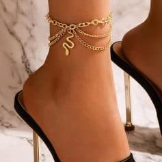 Elegant gold ankle bracelet with snake pendant, layered chains, and trendy style. Perfect accessories for women to enhance fashion and footwear.