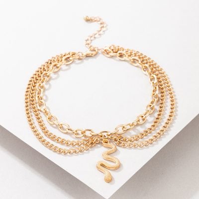 Elegant layered gold snake pendant necklace with multiple chain styles for women. Perfect accessory for fashion and statement jewelry enthusiasts.