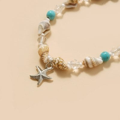 Beach-inspired jewelry with seashells, turquoise beads, and starfish charm, perfect for summer beachwear or ocean-themed fashion accessories.