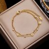 Gold jewelry bracelet featuring daisy charms and sparkling crystals, ideal for gift-giving or everyday fashion.