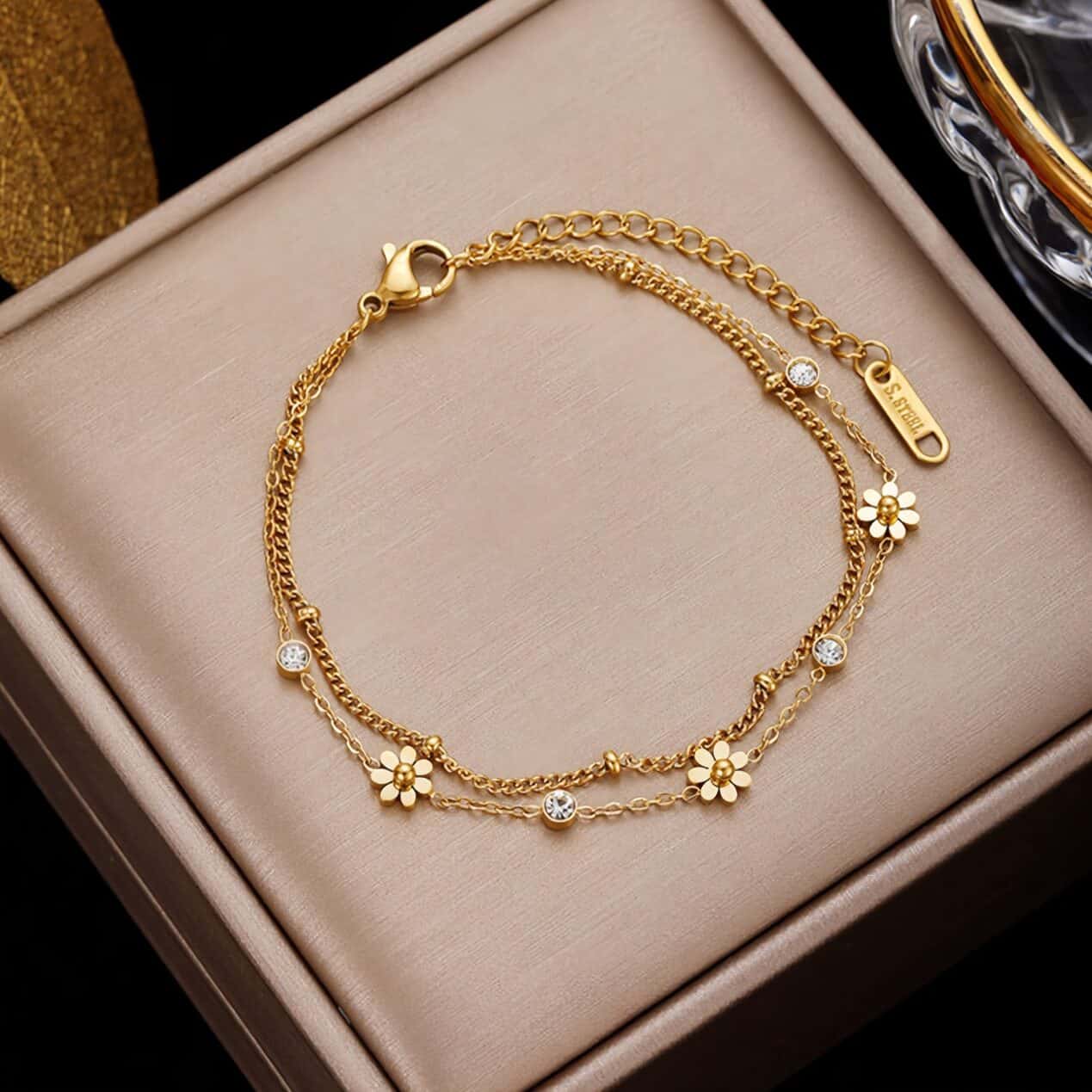 Gold jewelry bracelet featuring daisy charms and sparkling crystals, ideal for gift-giving or everyday fashion.
