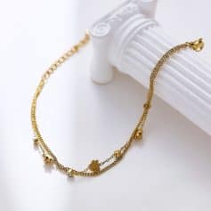 Delicate gold-toned layered necklace with floral and cubic accents, perfect for formal or casual occasions, highlighting stylish jewelry pieces.