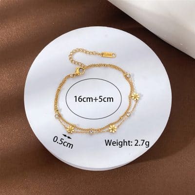 Elegant gold bracelet with flower charms and small crystals, adjustable length, lightweight design, suitable for fashion-forward jewelry lovers.