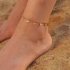 Gold anklet jewelry for women, perfect for beach or casual wear, featuring small dangling charms, lightweight and stylish. Ideal accessory for enhancing summer outfits and beach looks.