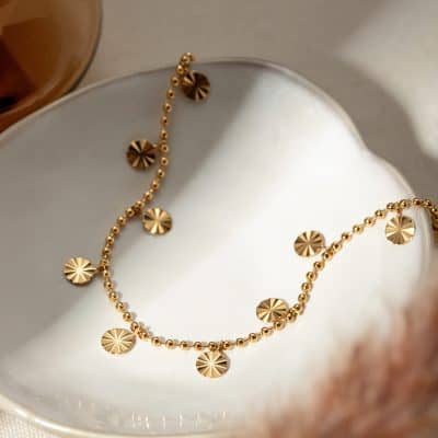 High-quality gold beaded jewelry with circular pendant accents, ideal for stylish accessories or personal adornment. Perfect for those seeking luxury and sophistication in jewelry.
