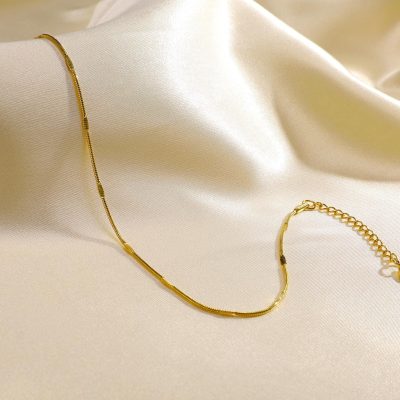 Stunning gold necklace displayed on silky white fabric, perfect for women seeking luxury jewelry; ideal for all occasions, gift-giving, and enhancing your style.
