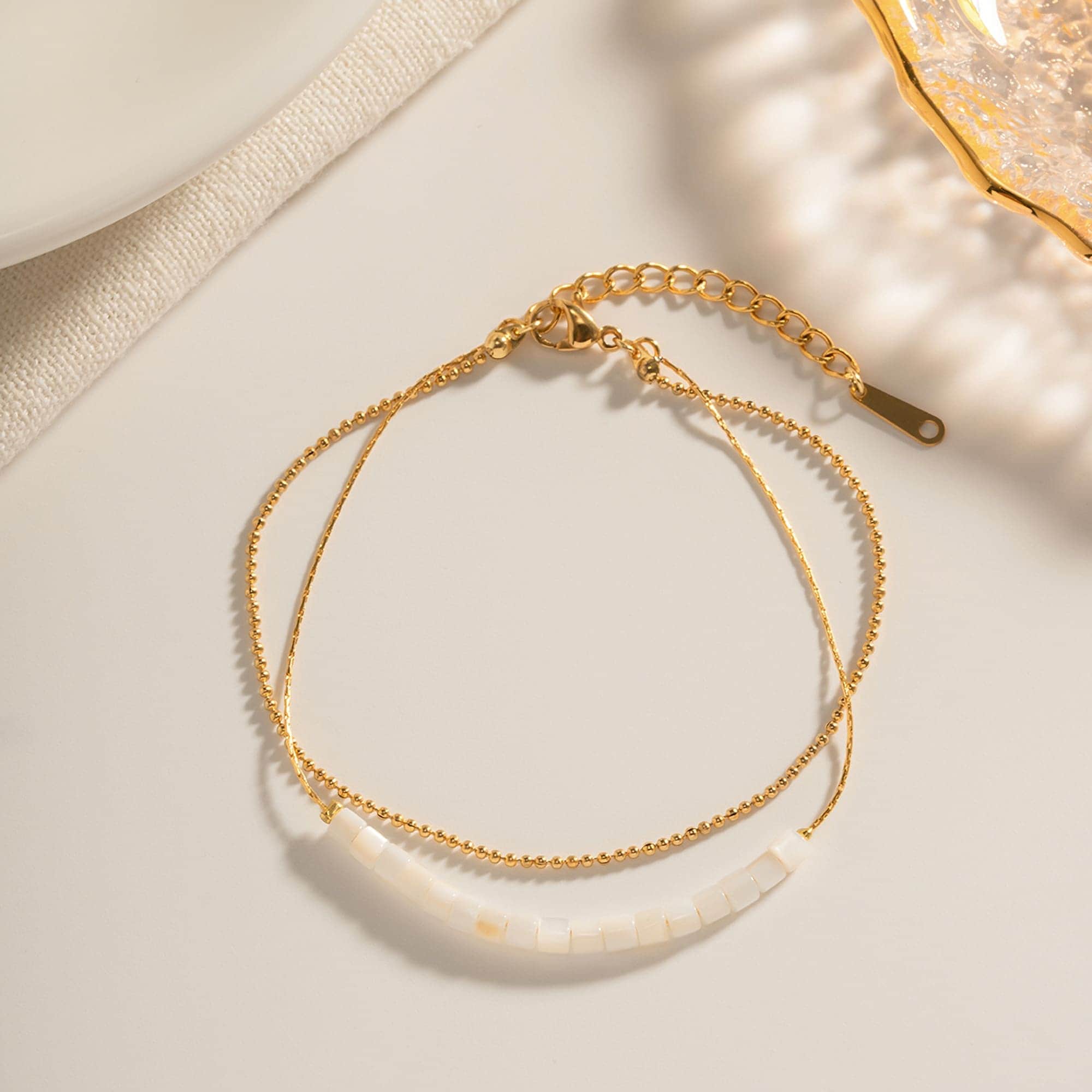 Delicate gold chain necklace with white pearl beads, perfect for stylish and sophisticated women. Ideal for adding a touch of elegance to any outfit.