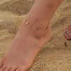 Delicate gold anklet featuring small charms and sparkling crystal accents, perfect for beachwear or everyday summer style, available at Monalisa Store.