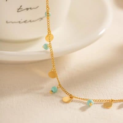 Delicate gold and turquoise charm necklace, perfect for elegant fashion accessories and jewelry lovers.