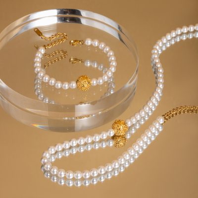 Alt text: Luxurious pearl necklace and bracelet with gold beads displayed in a clear glass dish, perfect for sophisticated accessorizing at Monalisa Medical Store.