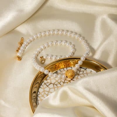 Aluminum pearl necklace with matching bracelet and gold accent clasp, perfect for sophisticated women seeking stylish, high-quality jewelry.