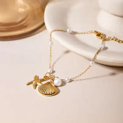 Delicate gold necklace with pearl accents and seashell charm, perfect for beach-inspired or summer accessories. Elegant jewelry piece from Monalisa Store, ideal for stylish women.