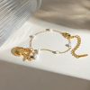 Delicate gold chain necklace with seashell and starfish pendants, accented with white pearls, ideal for beach-inspired fashion and accessorizing stylish looks.