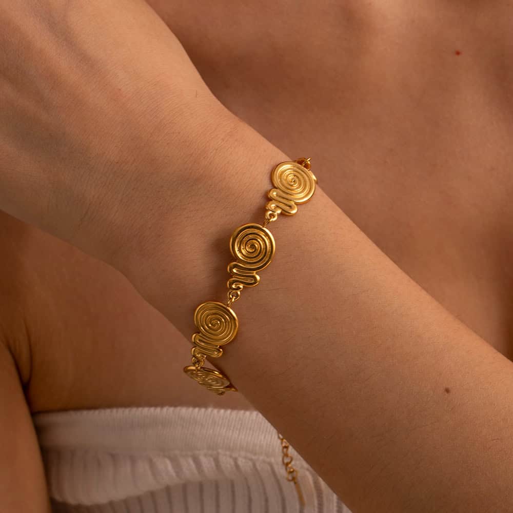 Close-up of a stylish gold spiral bracelet on a woman's wrist, showcasing exquisite jewelry craftsmanship perfect for enhancing your accessories collection.