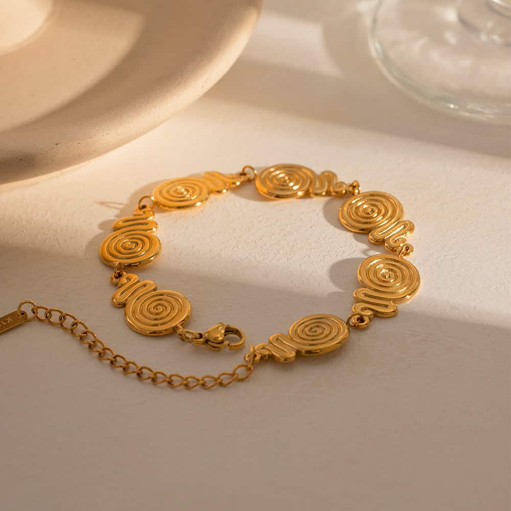 Close-up of a stylish gold spiral bracelet, perfect for women’s fashion accessories and jewelry collections, showcased on a neutral background for a refined look.