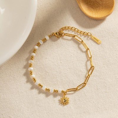 Delicate gold and pearl bracelet featuring a snowflake charm, perfect for stylish accessories. Ideal for special occasions or everyday wear from Monalisa Store.