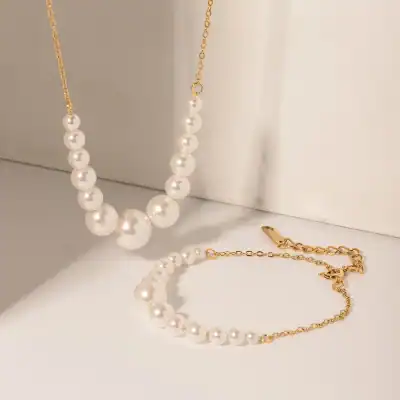 Delicate pearl jewelry set featuring a stylish pearl necklace and matching bracelet with gold chain accents, perfect for enhancing your outfit.
