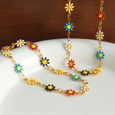 Bright, colorful daisy chain necklace and bracelet with gold links, perfect for summer accessories and fashion statements.