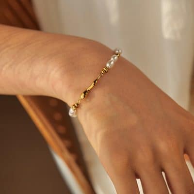 A close-up of a women's wrist adorned with a sophisticated pearl and gold bracelet, highlighting Monalisa Store's jewelry collection.