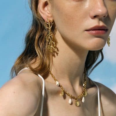 Stunning gold earrings and necklace with shell and leaf design perfect for fashionable women.