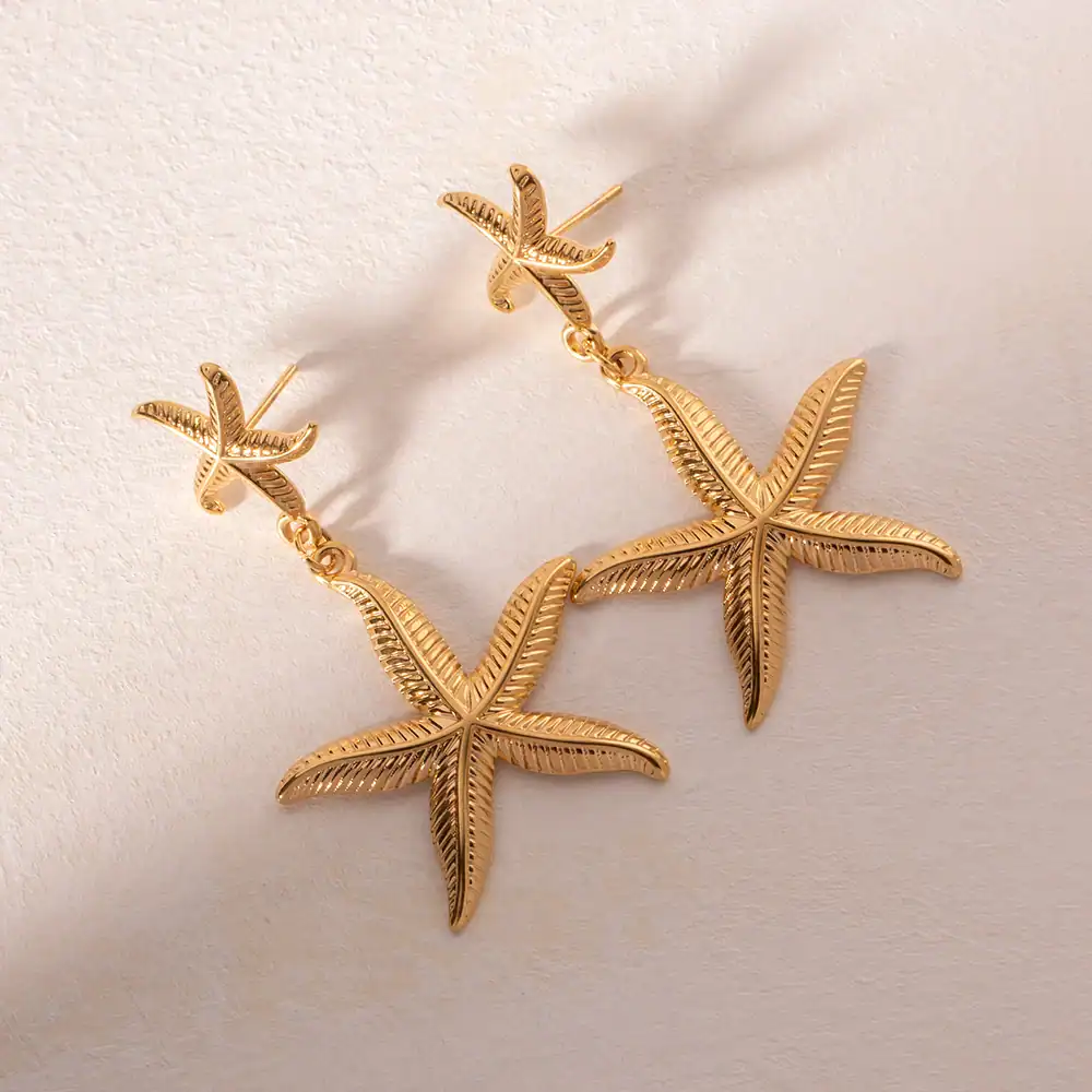 Gold tropical leaf statement earrings, perfect for summer and beachwear, crafted with intricate leaf design, lightweight and stylish. Ideal for fashion-forward individuals seeking unique jewelry pieces.