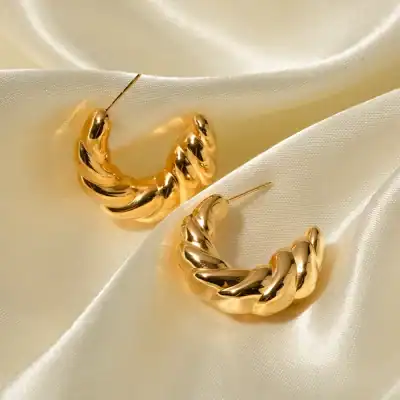 Elegant gold hoop earrings with a twisted design, perfect for women's fashion accessorizing. High-quality jewelry ideal for stylish occasions and gifting.