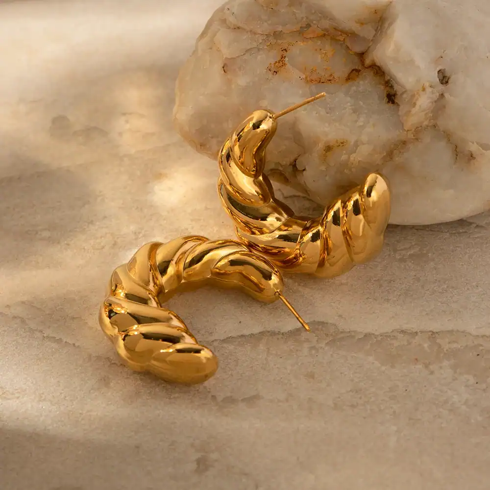 Elegant gold hoop earrings with a unique twisted design, perfect for adding a touch of sophistication to any outfit.