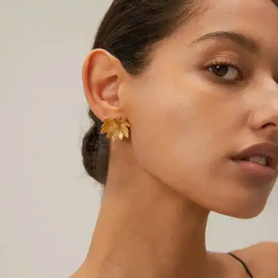 Stunning gold flower-shaped earring, perfect accessory piece for sophisticated fashion and jewelry lovers.