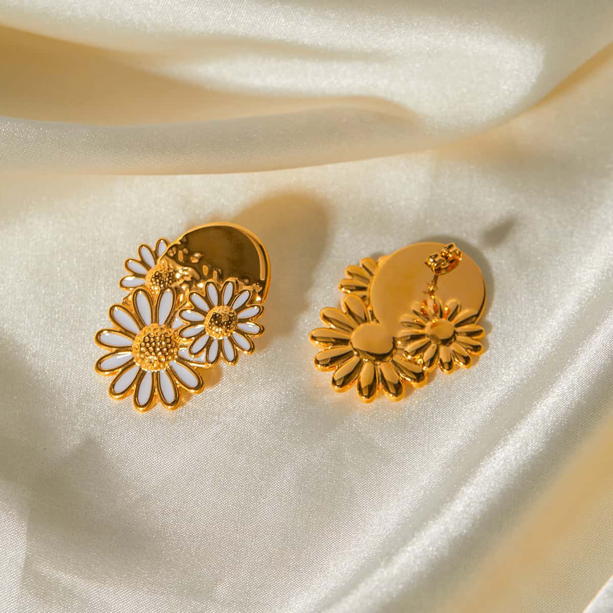 Elegant gold earrings featuring daisy-shaped cutouts and intricate floral details, perfect for enhancing your style and complementing modern or classic looks.