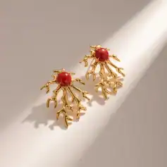 Gold coral earrings featuring red gemstones, ideal for luxury jewelry and special occasions.