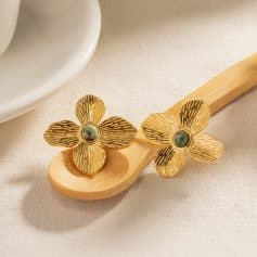 Beautiful gold floral earrings featuring intricate petal design and central green stone, perfect for sophisticated accessories and stylish fashion statements.